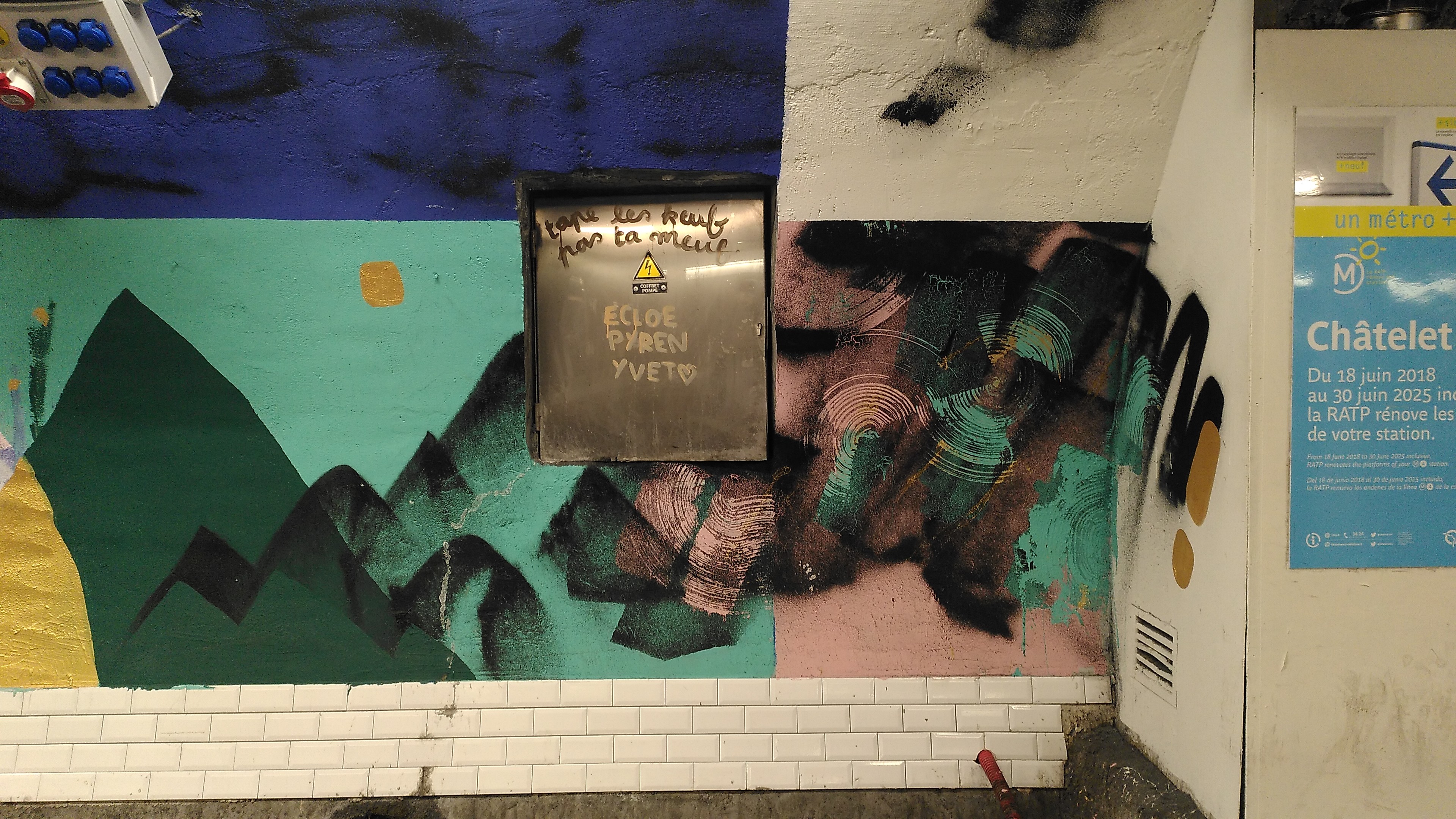 A wall of a subway station with some mountain-like abstract painting. In the middle is a maintenance door with on it written 