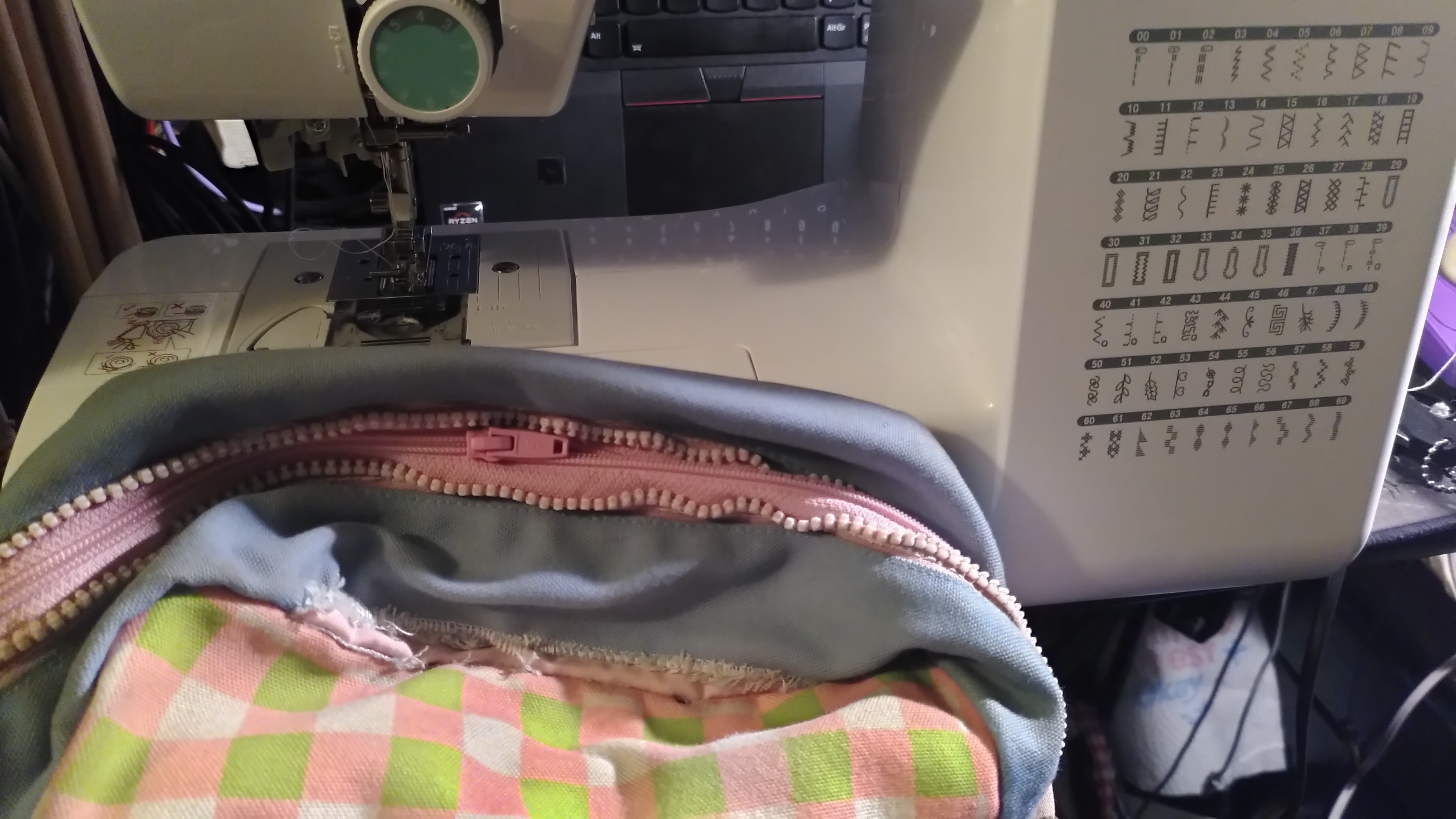 A bag in not so great shape in front of a sewing machine