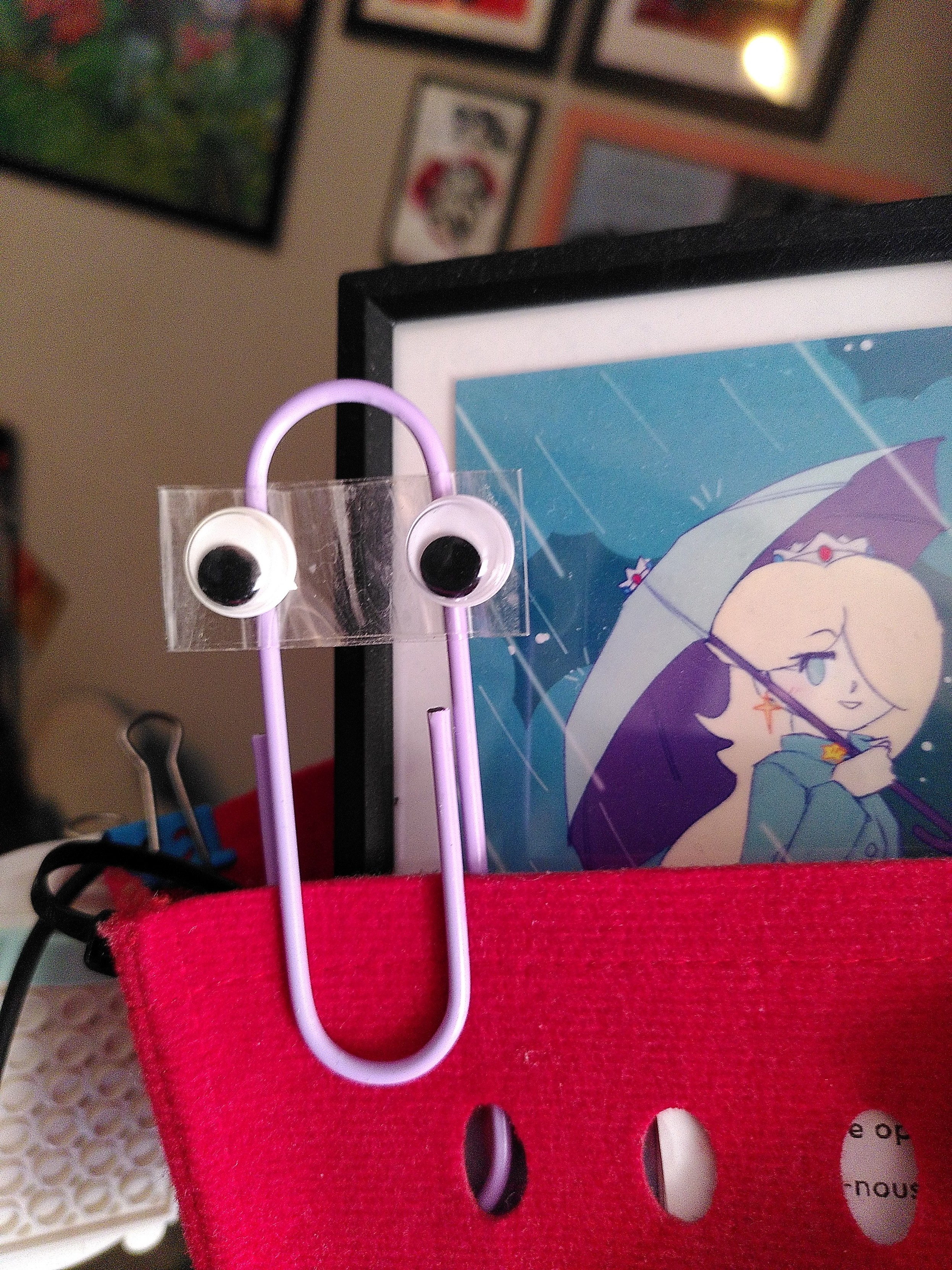 An oversized paperclip and a pair of googly eye in the form of the microsoft beloved mascot. On the side is a mini print by doodlemancy