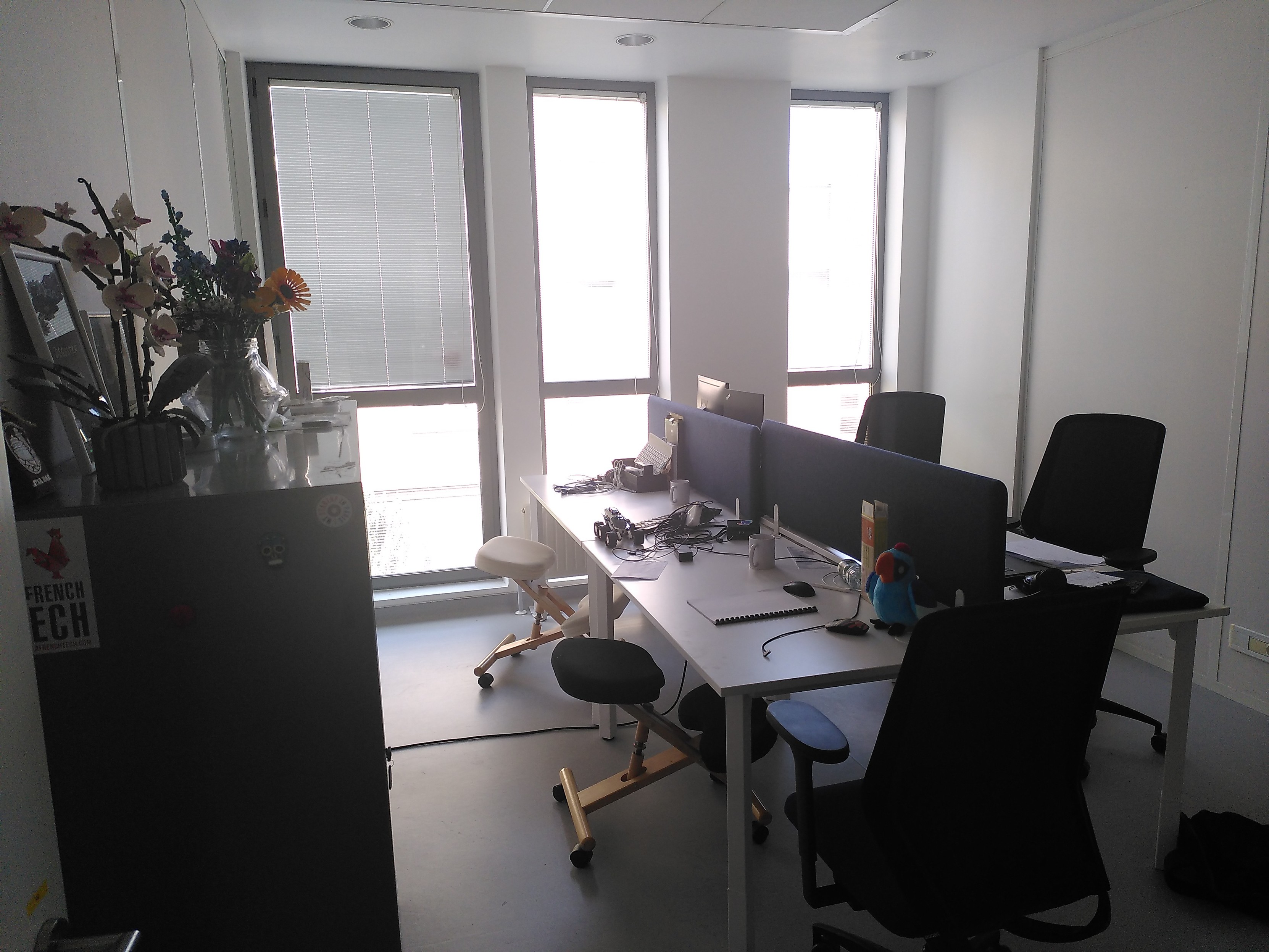4 desks stuck together in an office, divided with an anti-noise panel