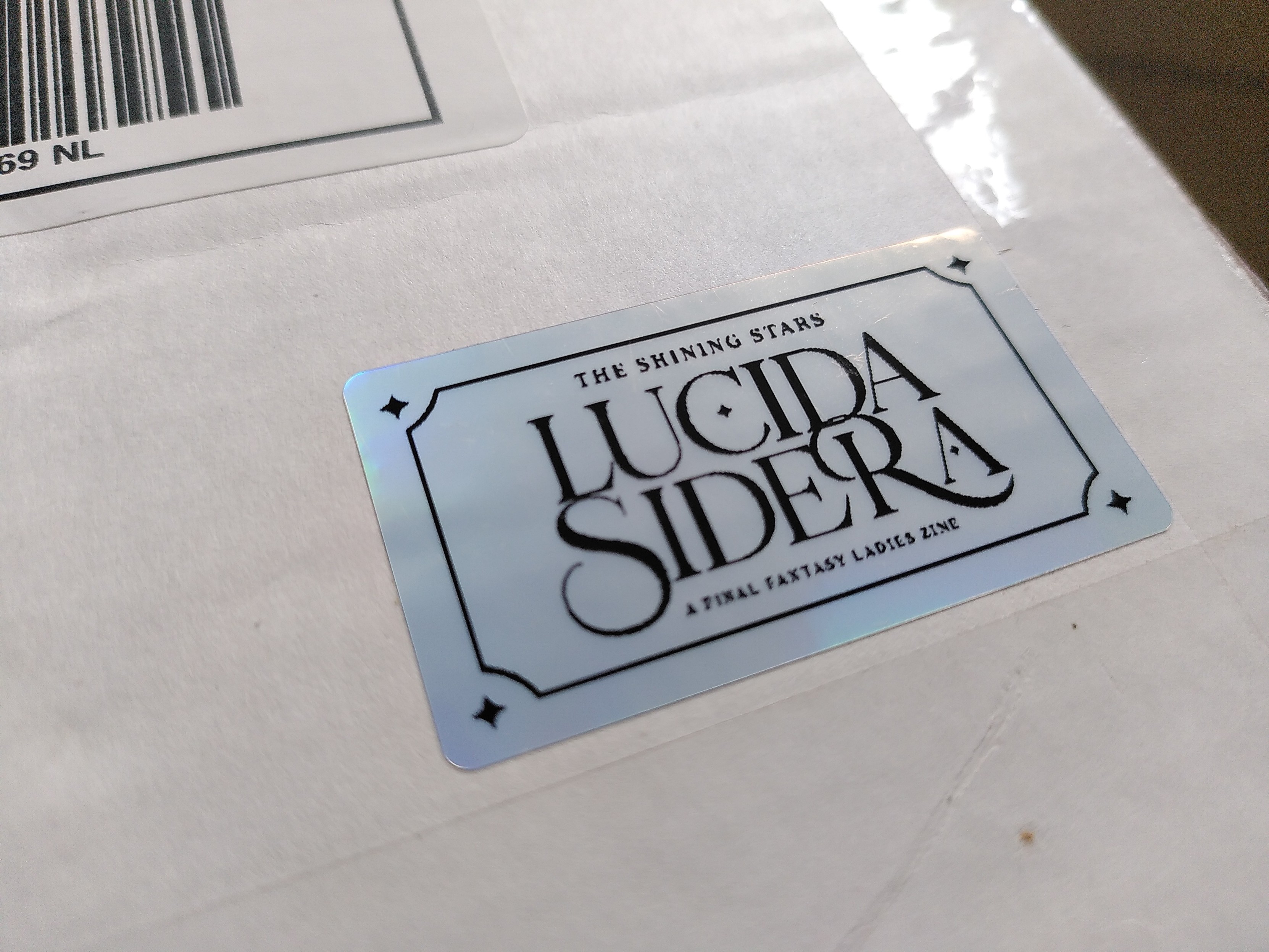holographic sticker on a package saying the shining stars LUCIDA SIDERA a final fantasy ladies zine
