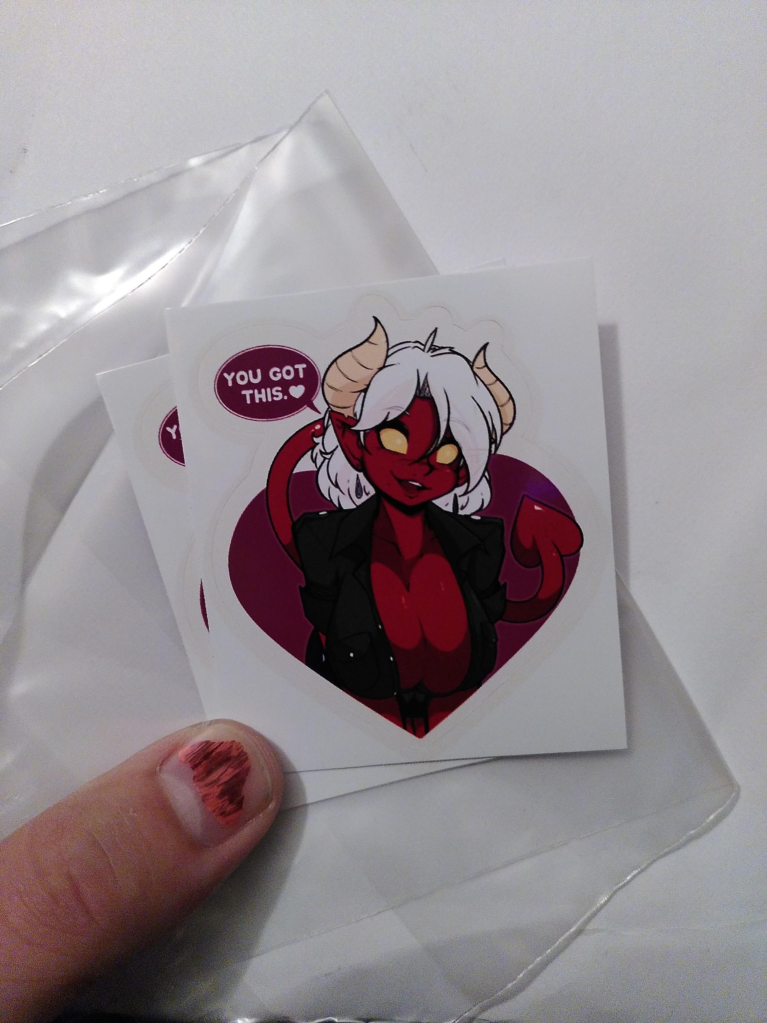 A pair of sticker sporting a demon babe with big cleavage encouraging you