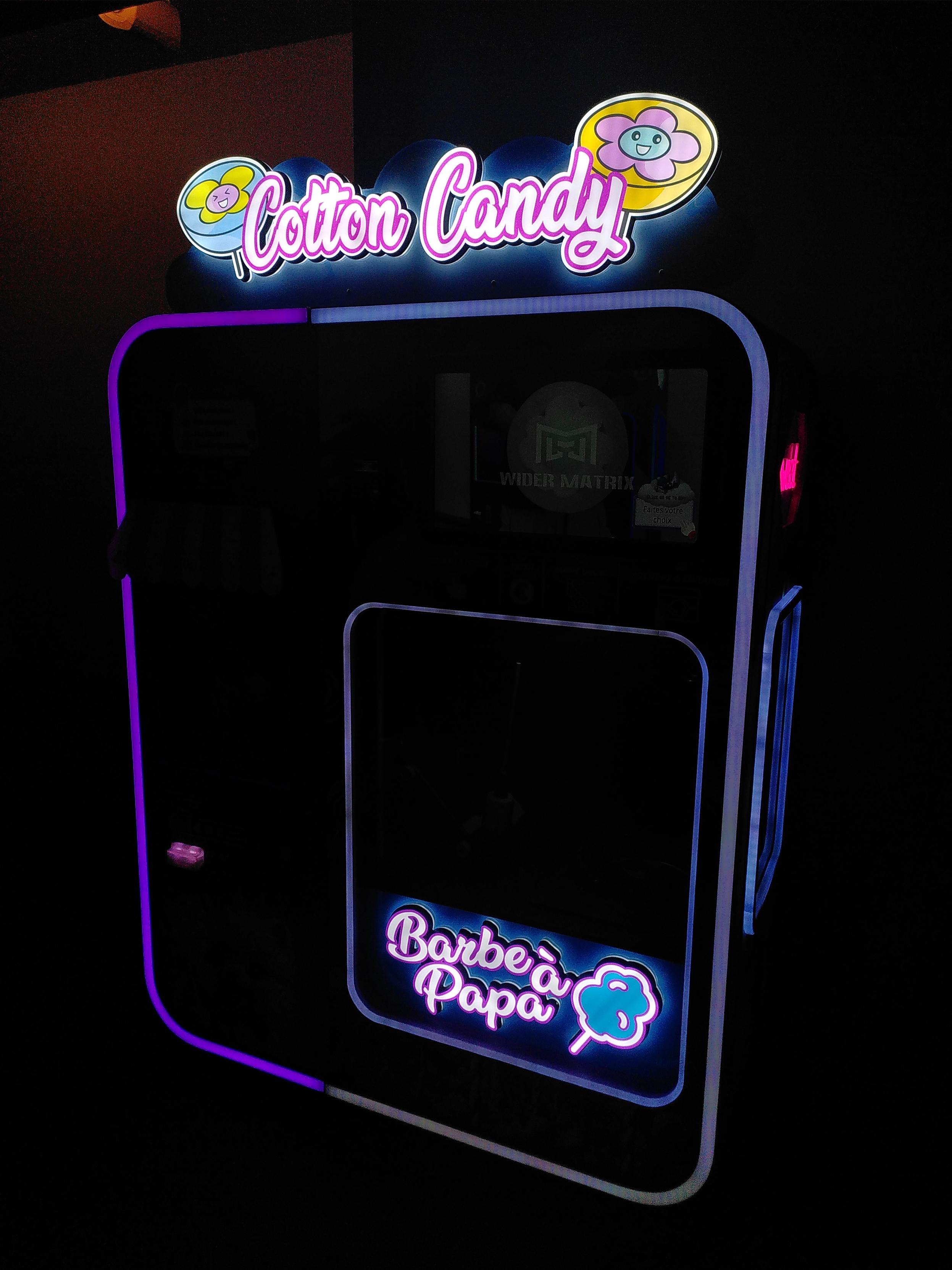 An automated cotton candy machine. White balance is off so the neon part are not washed off in light