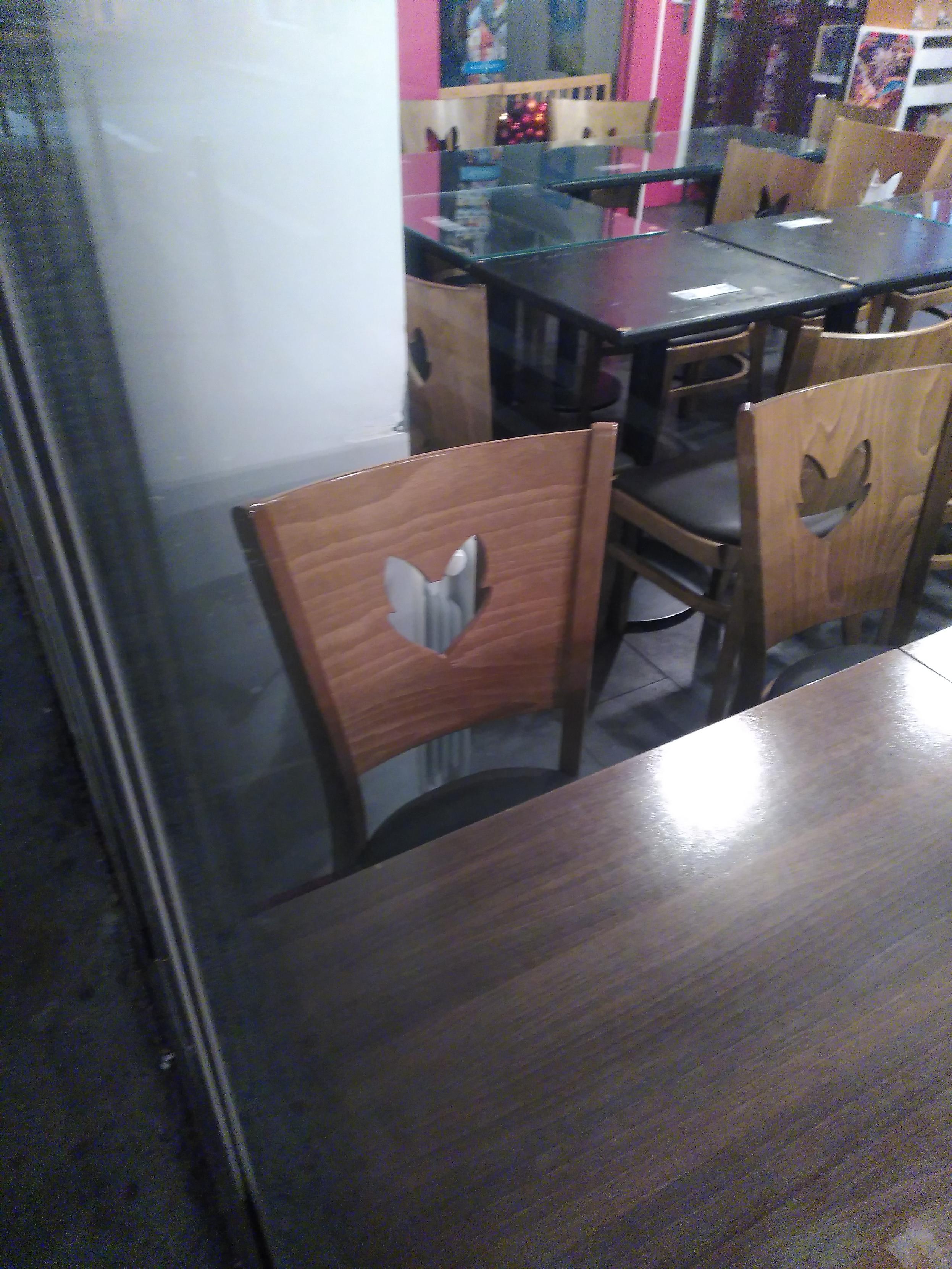 A chair from the meisia, a boardgame café, featuring their fox-like logo cut in the back of the chair