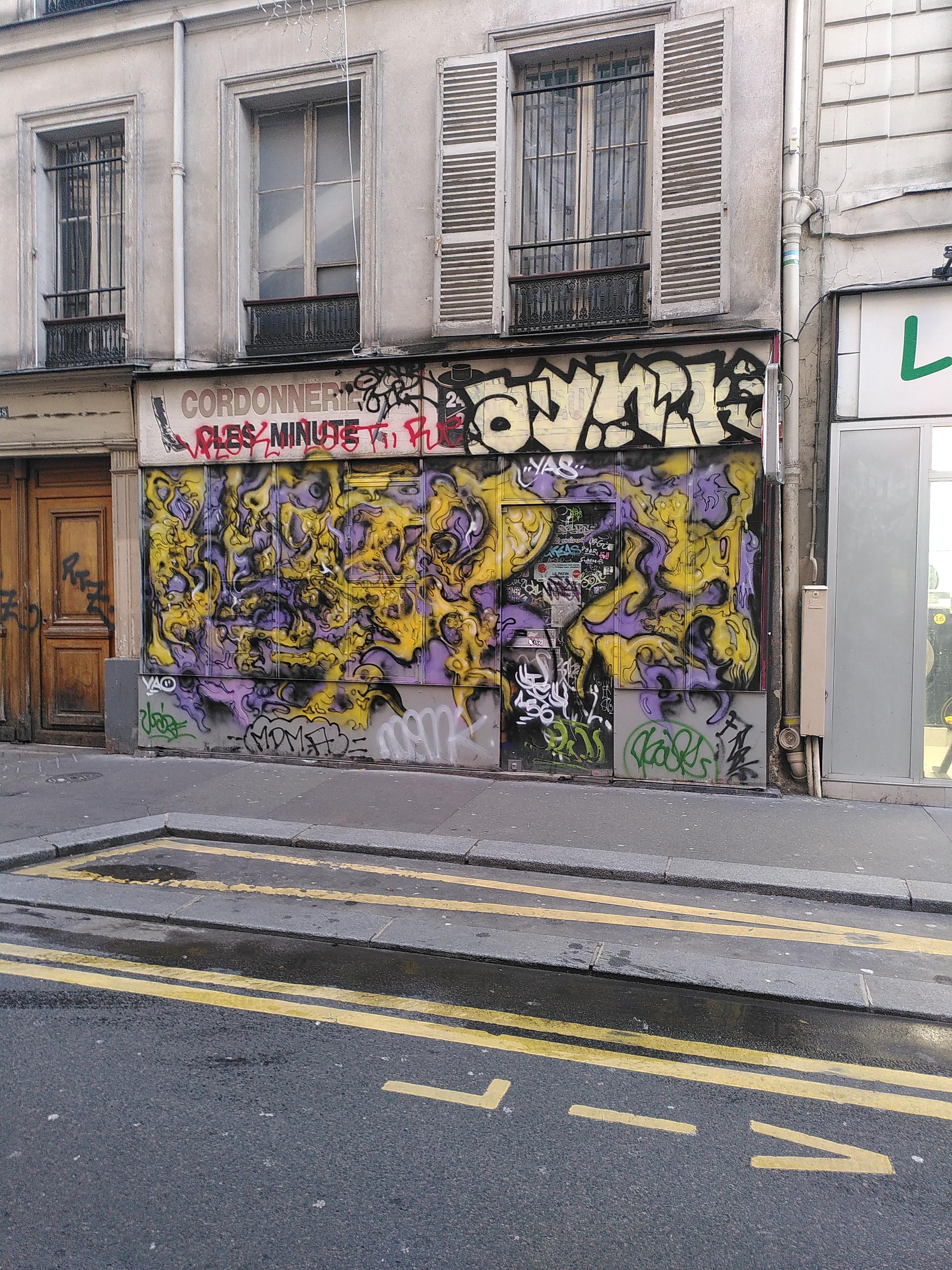 A closed shop facade covered in yellow and purple graph