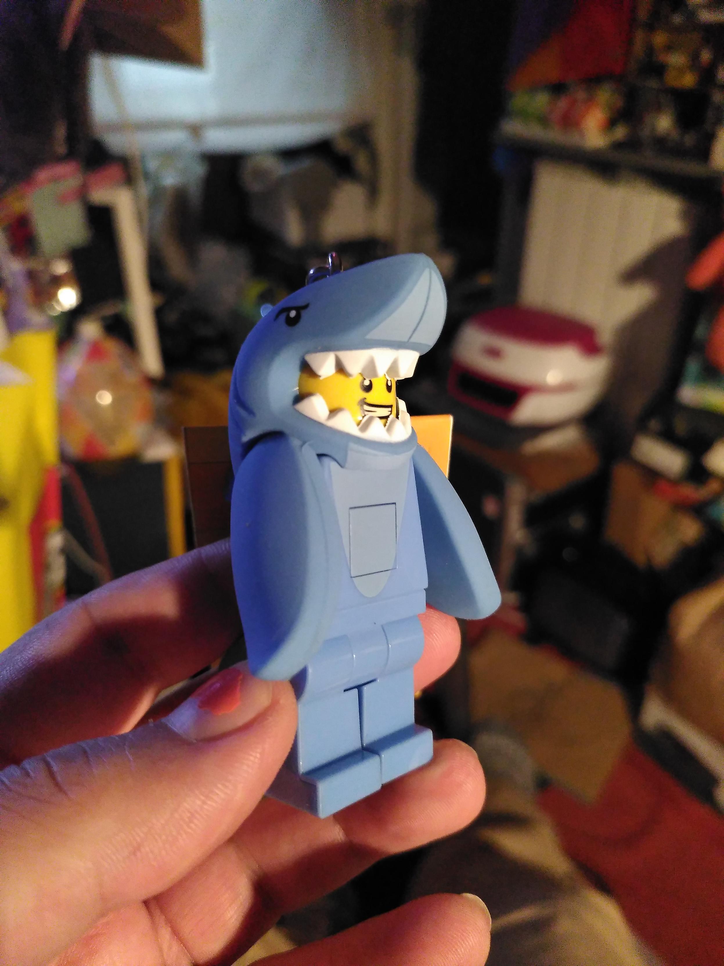 Lego figurine of a person in a shark costume. It's belly double as a button to turn on leds in its feet