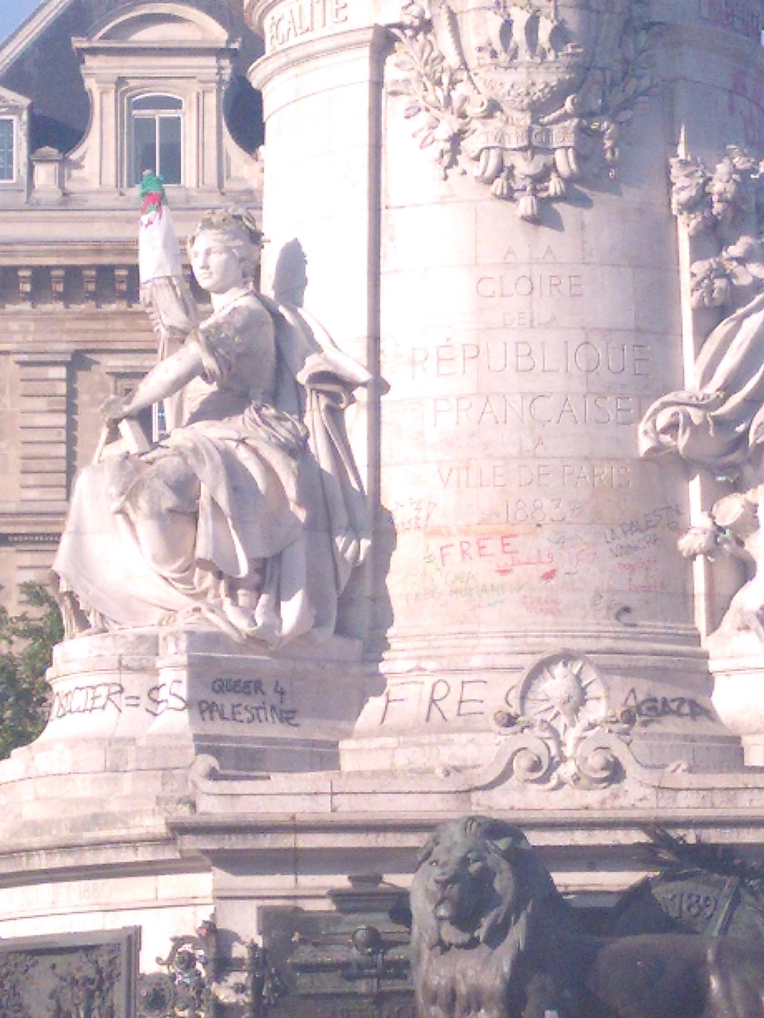 A photo of a part of the sculpture on republic square in paris. There are numerous writing and in the center 