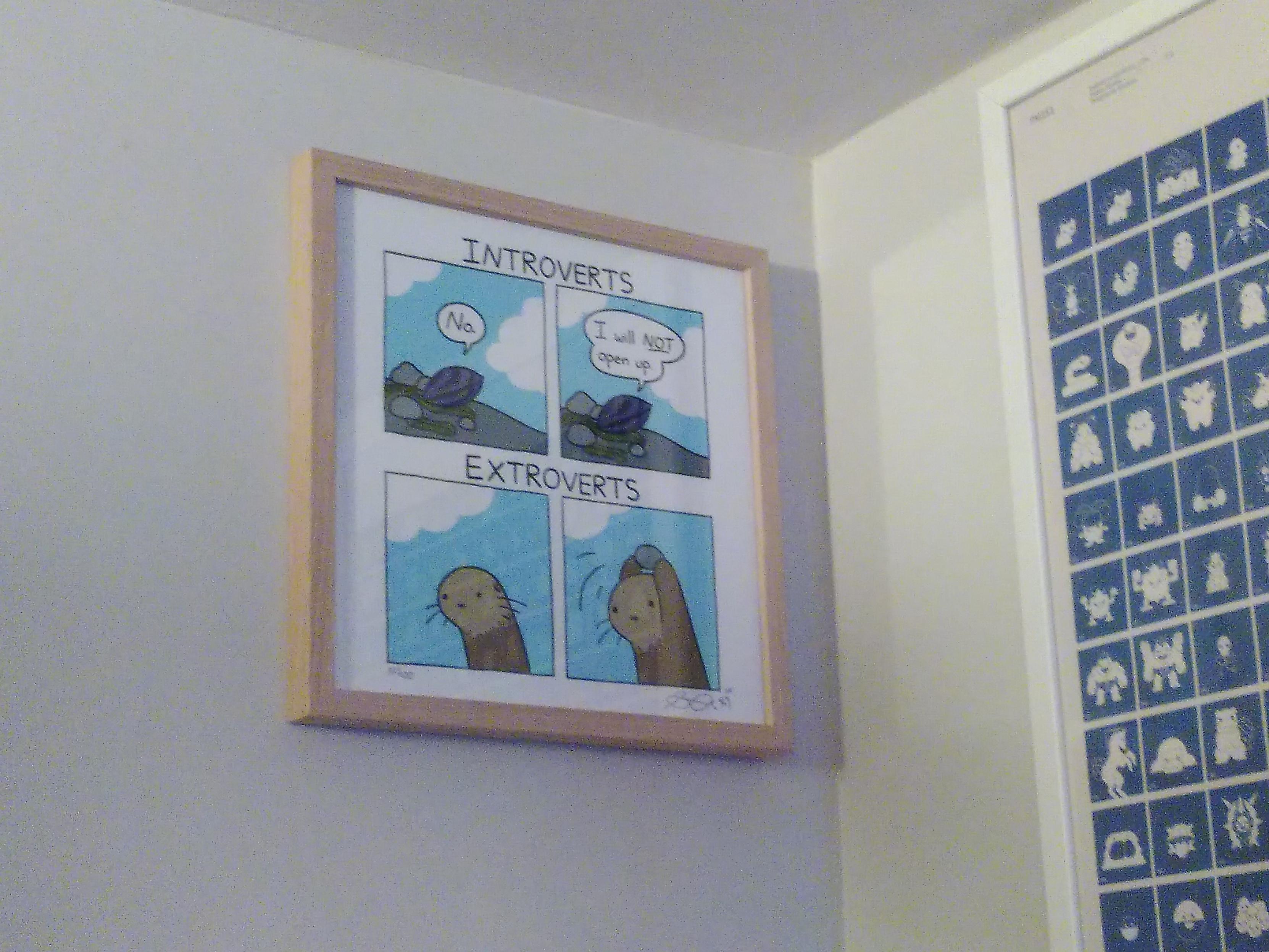 A framed print of a sarah's scribbles' comic hanging on a wall. The first two case are titled introvert and sport a shellfish saying no and I will *not* open up. The other two cases are title 