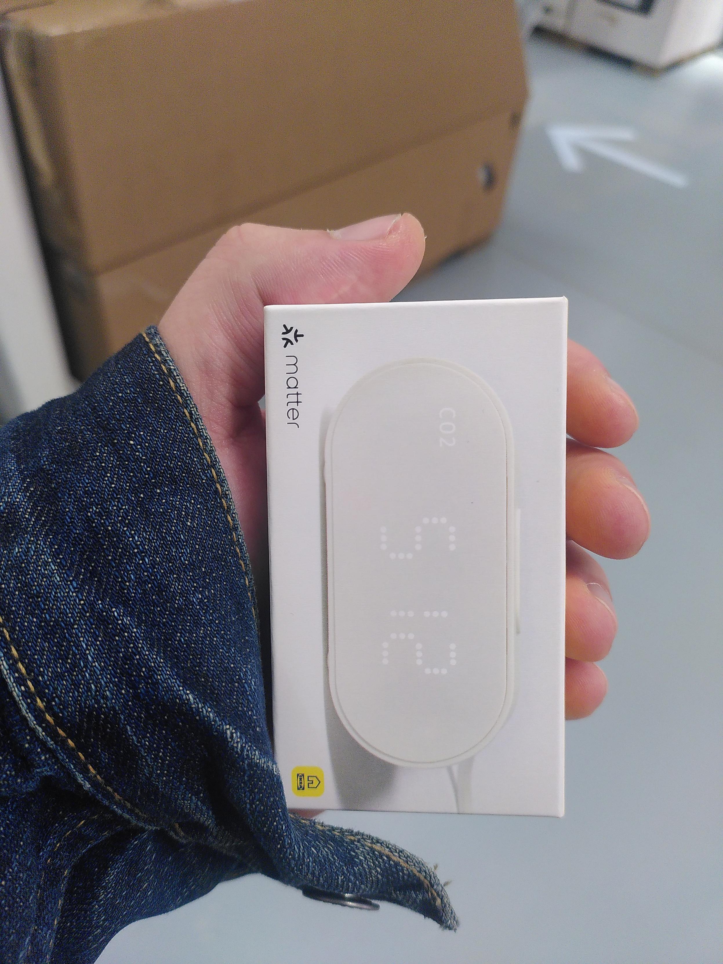Photo of my hand holding an alpstuga, ikea CO², pm², temperature and humidity sensor. My hand cover 3 sides of the box, 4 with the thumb over the top