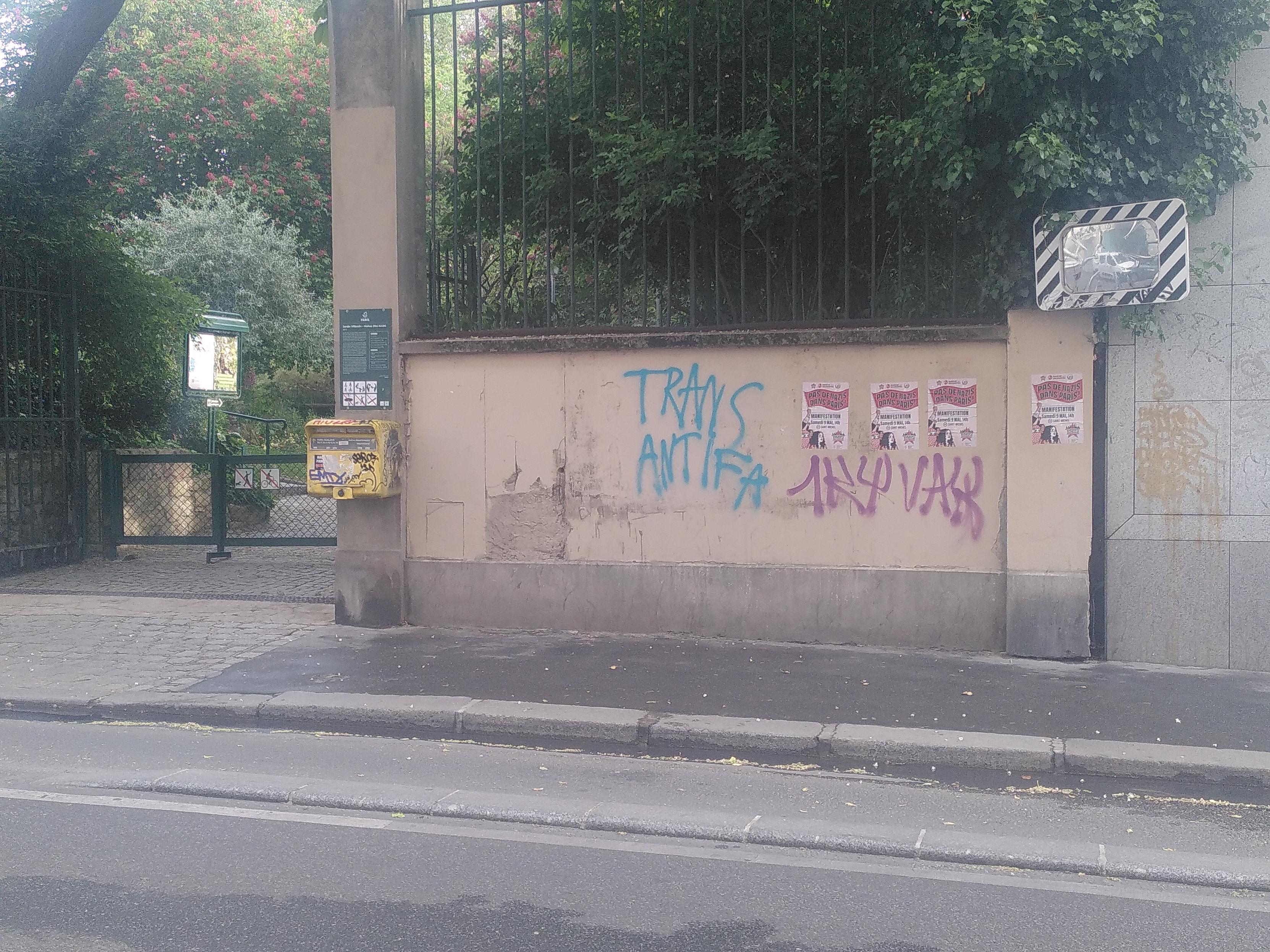 Outdoor photo inside paris. In focus is a wall with 