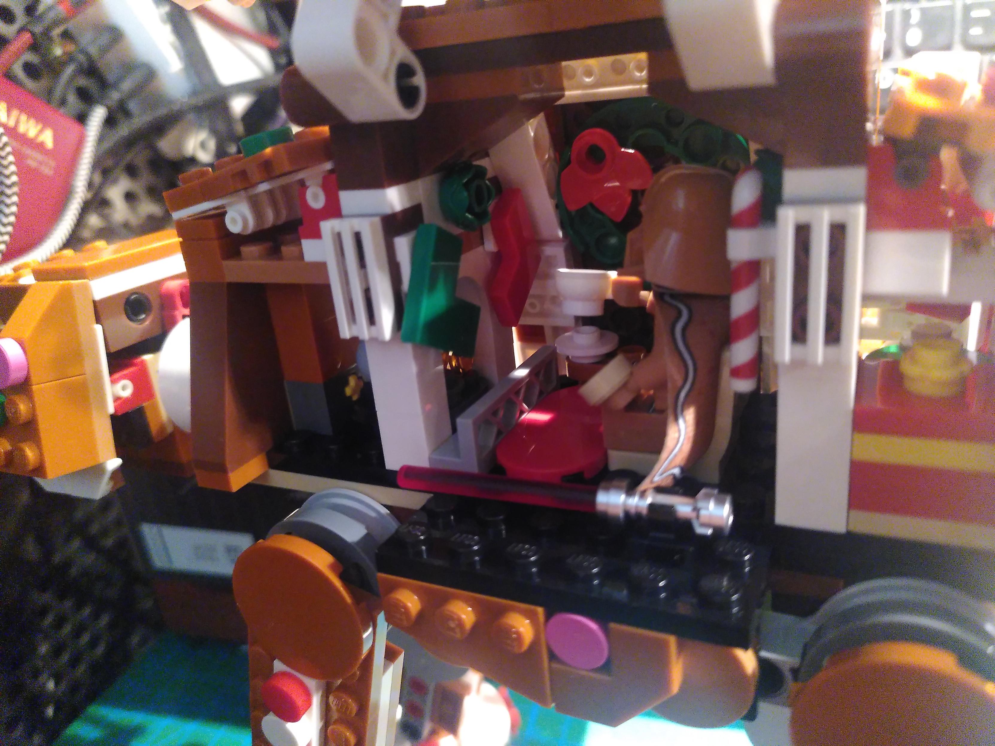 photo of lego gingerbread AT-AT from a slightly different angle, showing the fireplace with socks, a wreath, a carpet