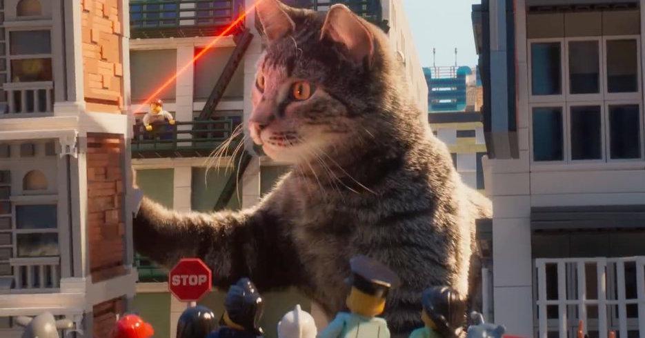 Frame from ninjago lego movie, featuring a real cat going after a real~ish red laser in a lego city